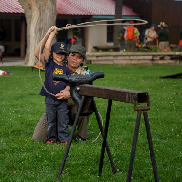 Scout leader and child using a lasso