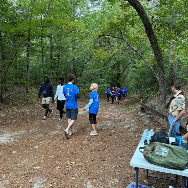 Walkers on the trail for the Father Sav Memorial Mission Walk, with Scouts staffing a water station