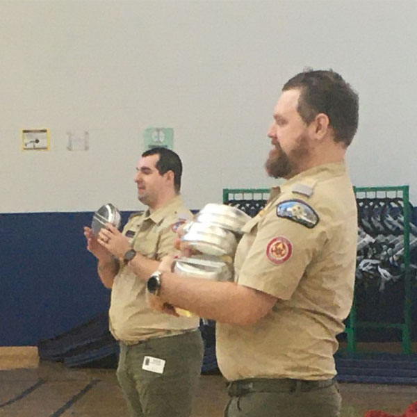 Two Boy Scouts of America district executives speaking to students at a school talk