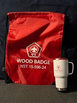 Red bag with Wood Badge NST 15-594-24 and white travel mug