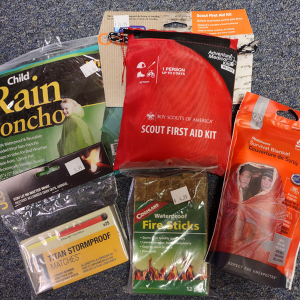 Scout Shop merchandise: child's rain poncho, stormproof matches, Scout first aid kit, waterproof fire sticks, & survival blanket