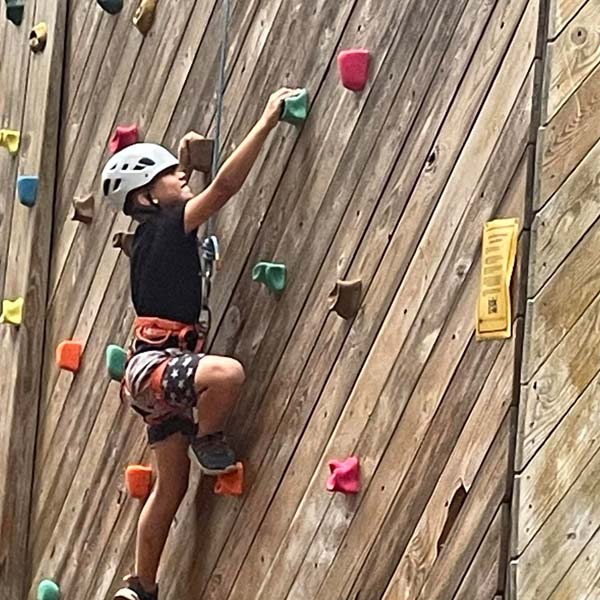 Cub Scout climbing on the climbing tower at Pipsico Scout Reservation